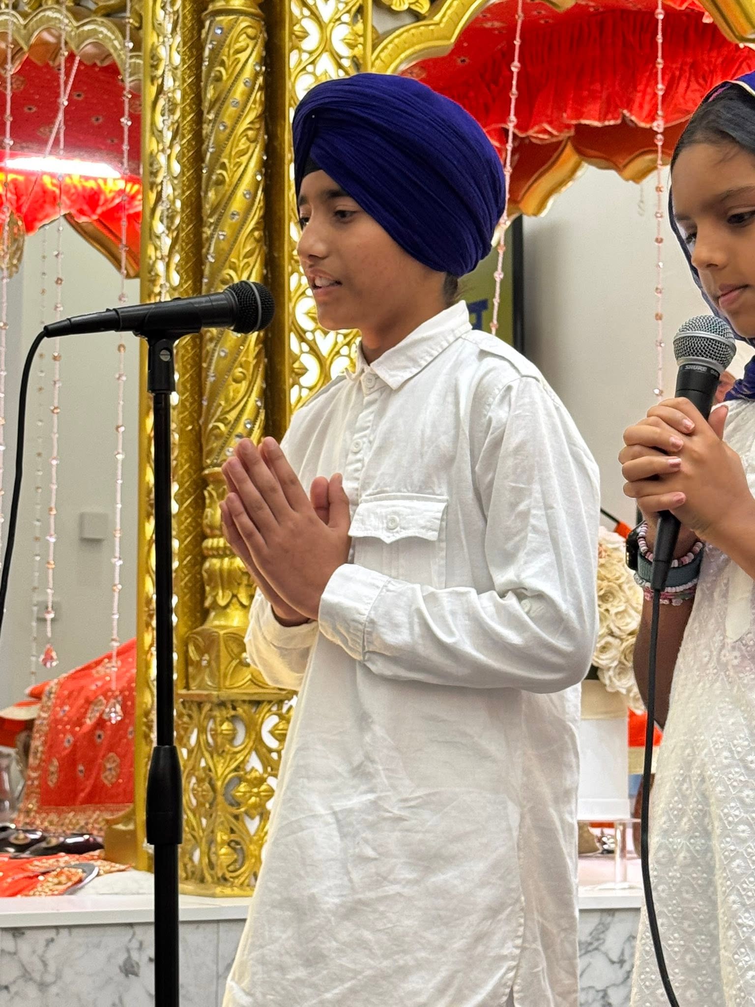 Children reciting at the microphone during a program