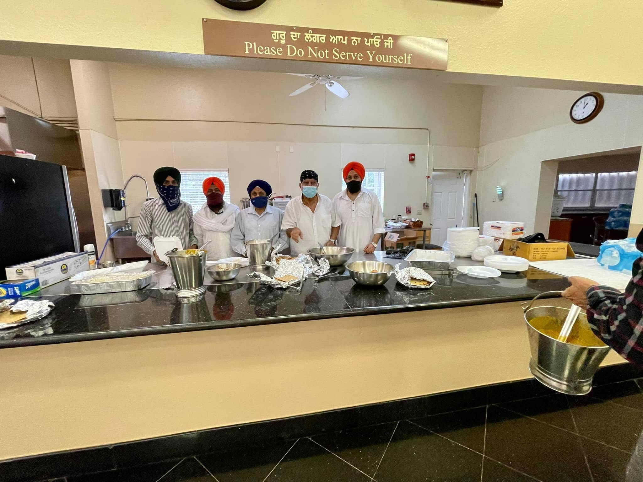 Sangat celebrating a Gurpurab with flowers and Kirtan