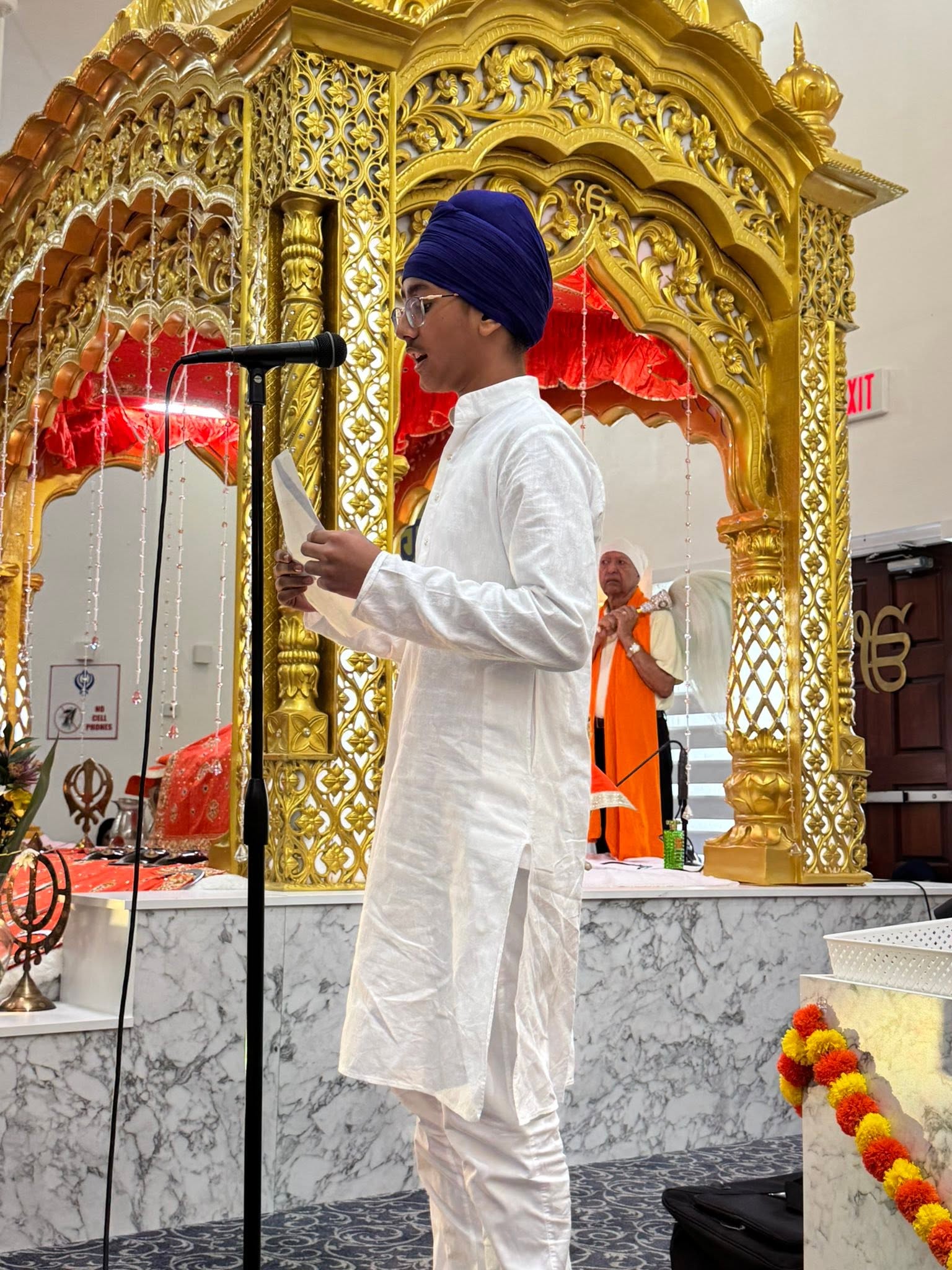 A youth reading at a program in the Darbar Sahib